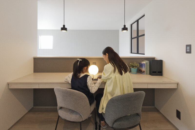 書斎スペースで子どもと勉強する親子の写真